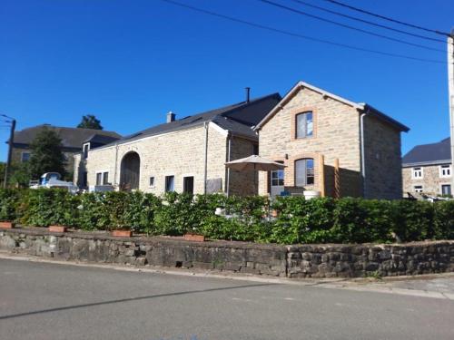 a brick house with an umbrella in front of a street at Le fournil de la Silentiaire in Opont