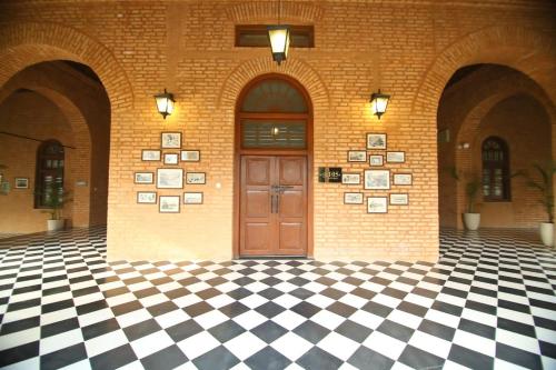 a door in a building with a checkered floor at Peshawar Barracks Hotel Estb-1867 in Peshawar