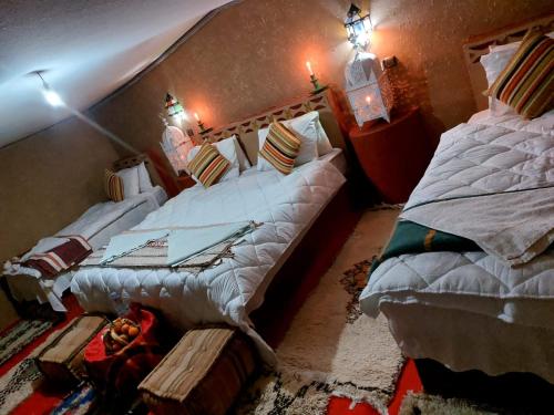 two large beds in a room with at Chegaga Luxury Camp in El Gouera