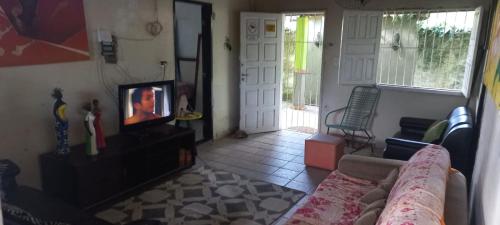 un soggiorno con divano e TV di Chácara Fênix a São Cristóvão