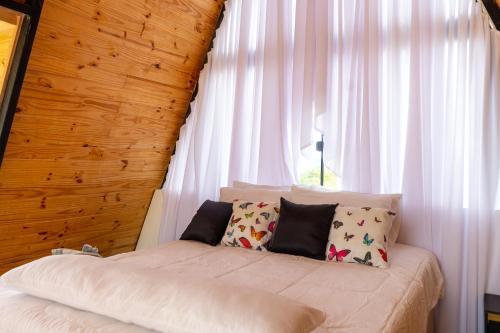 a bed in a room with a window at Cabana Serra do Cipó in Riacho Fundo