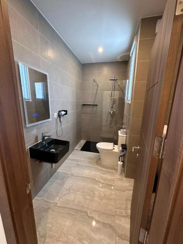 a bathroom with a toilet and a sink and a shower at La Bella Guesthouse in St Julian's