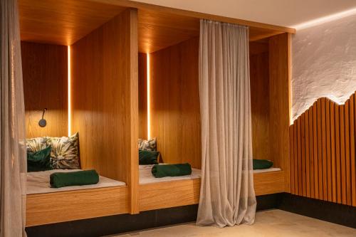 a room with two beds in a wooden wall at Hotel Oberwirt - nahe an Saalbach und Zell am See, Viehhofen Sommercard in Viehhofen