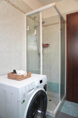 a washing machine in a bathroom with a shower at Appartamento Confortevole, vicino a CRO e Base USA in Aviano