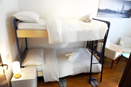 two bunk beds in a room with a desk at Appartamento Confortevole, vicino a CRO e Base USA in Aviano