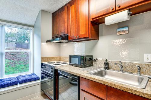 a kitchen with a sink and a stove at Lake Oswego Condo with Balcony, 3 Mi to the Water! in Lake Oswego