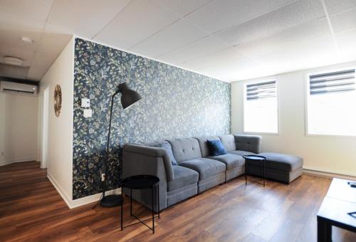 a living room with a couch and a blue wall at Le 1066 - Logement spacieux à Limoilou in Quebec City