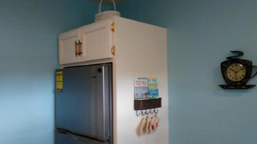 uma cozinha com um frigorífico e um relógio na parede em Private hideaway at The Phoenix guest suite em Moss Town