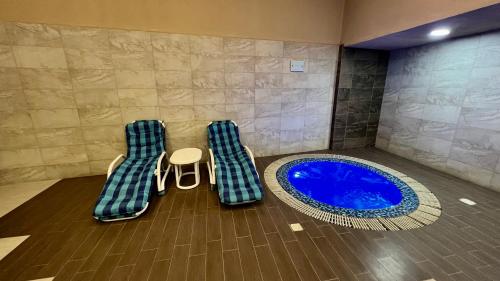 a room with a blue tub with a table and a stool at Centaurus Apartment in Islamabad