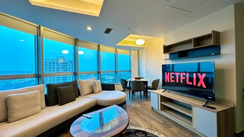 a living room with a couch and a television and a table at Centaurus Apartment in Islamabad