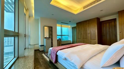 a bedroom with a large bed and large windows at Centaurus Apartment in Islamabad