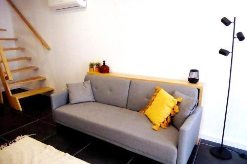 a couch with a yellow pillow on it in a room at Casas do Gavião by Portus Alacer in Gavião