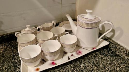 a tray filled with cups and a tea set on a counter at Centaurus Apartment in Islamabad