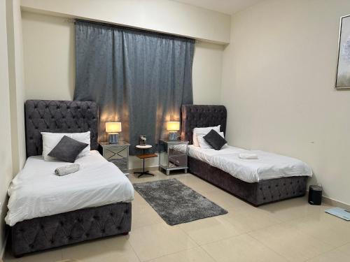 a bedroom with two beds and a window at LADIES ONLY - BED IN THE ROOM - Near Metro Station in Dubai