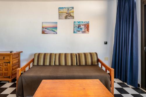 een slaapkamer met een bed en een houten tafel bij Apartamento Bilo 302 in Es Pujols