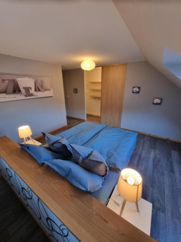 1 dormitorio con 1 cama con edredón azul en Le gîte de Cléo, maison spacieuse et paisible. en Metzeral
