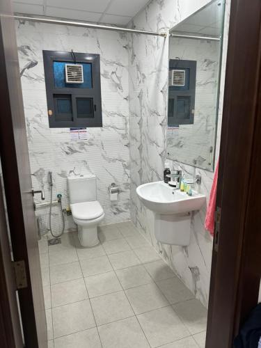 a bathroom with a toilet and a sink at LADIES ONLY - BED IN THE ROOM - Near Metro Station in Dubai