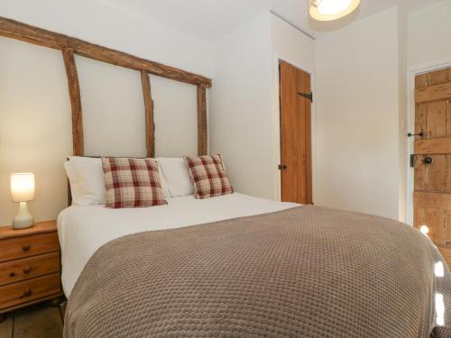 a bedroom with a large bed with a wooden headboard at 1 Tump Cottages in Hereford