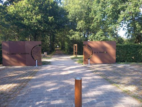 einen Weg mit zwei Auslegungszeichen in einem Park in der Unterkunft Le Temps d'une Pause au Calme in Bouaye