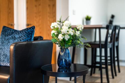 a blue vase with white flowers on a table at Telford House in Luton