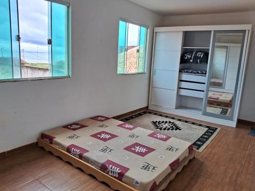 Zimmer mit einem Bett in einem Zimmer mit Fenstern in der Unterkunft CABO FRIO, SUITES PÉ AREIA in Cabo Frio