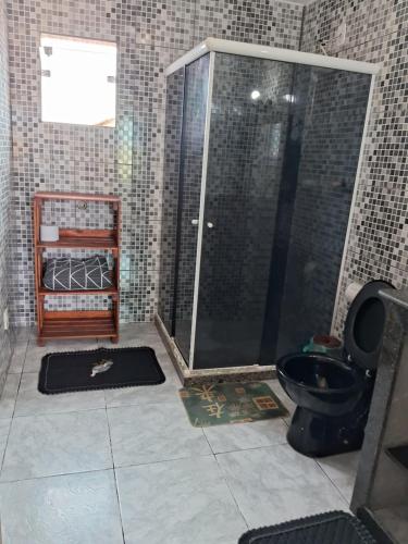 uma casa de banho com um chuveiro e um WC. em CABO FRIO, SUITES PÉ AREIA em Cabo Frio