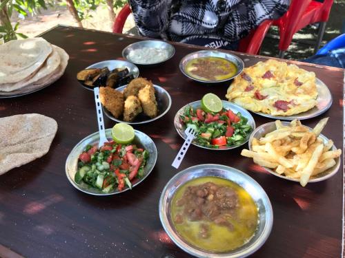 einen Tisch mit Teller mit Speisen und Pommes frites in der Unterkunft Sekhmet Retreat Centre in Luxor