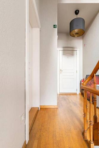 a hallway with a staircase and a white door at Suite Stays Bruges in Bruges