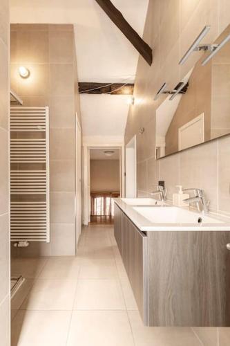 a large white bathroom with a sink and a counter at Suite Stays Bruges in Bruges