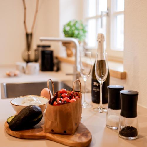 a table with a bowl of fruit and a bottle of wine at Gasthaus Faust in Knittlingen