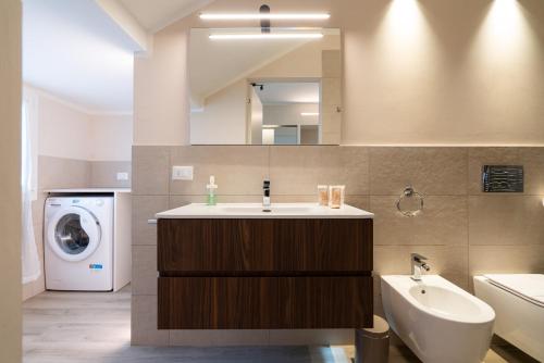 ein Badezimmer mit einem Waschbecken und einer Waschmaschine in der Unterkunft Palazzo Marsili Serenity in Bologna