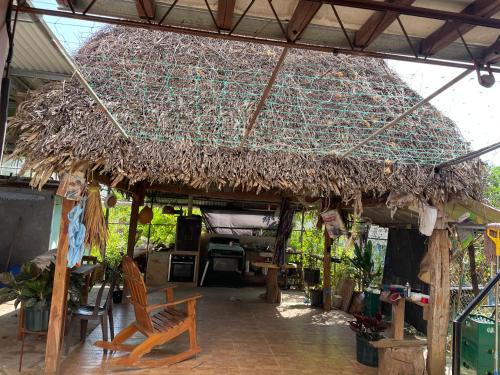 a large straw roofed building with a bench under it at Casa para los 4 días de carnavales en Chitré 