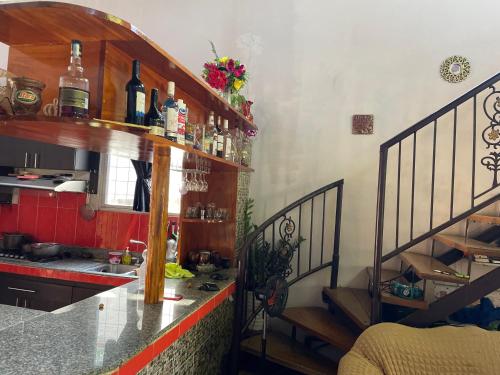 uma cozinha com um lavatório e um balcão com garrafas de vinho em Casa para los 4 días de carnavales en Chitré 