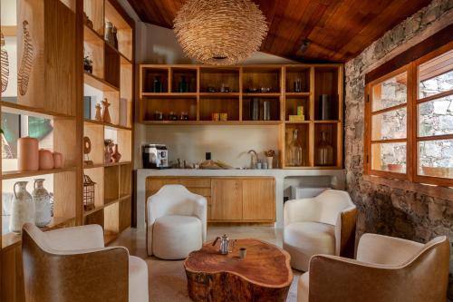 Refúgio na Serra Boutique Hotel في موسوجي: غرفة معيشة مع طاولة وكراسي