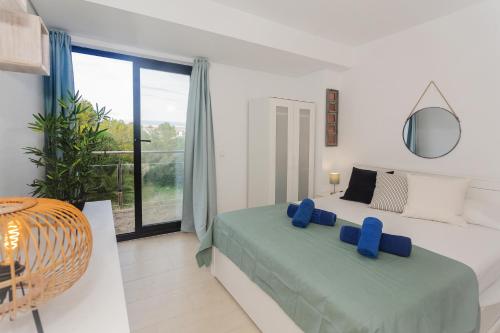 a bedroom with a bed and a large window at Sa Perdiu 14 in Cala Santandria