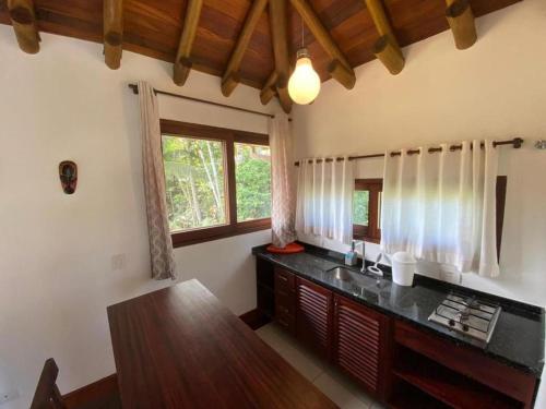 cocina con encimera, fregadero y ventana en Thai Pousada, en Ubatuba