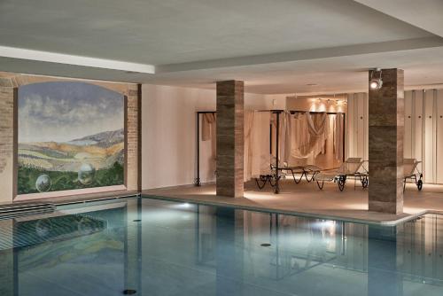 a swimming pool in a building with a painting on the wall at Borgo Lanciano in Castelraimondo
