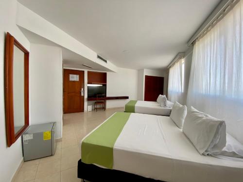 a bedroom with two beds and a living room at Hotel Dorado Plaza Bocagrande - All Inclusive in Cartagena de Indias