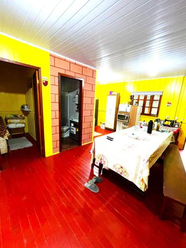een kamer met een tafel en een gele muur bij Sítio Nature in Rancho Queimado
