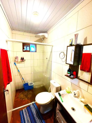 een badkamer met een douche, een toilet en een wastafel bij Sítio Nature in Rancho Queimado