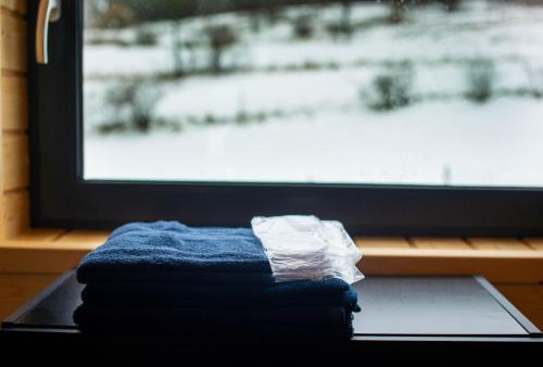 a pile of towels sitting on a table in front of a window at Widokowe Stodoły in Chyszówki