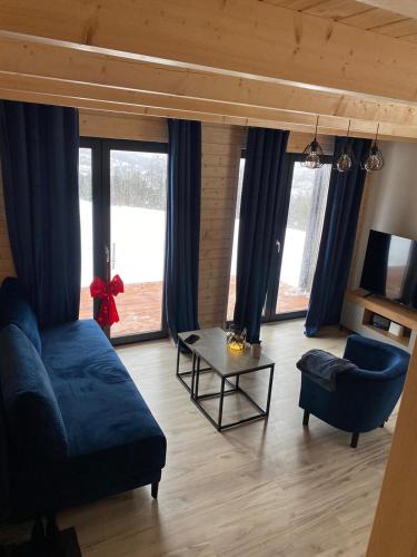 a living room with a blue couch and a table at Widokowe Stodoły in Chyszówki