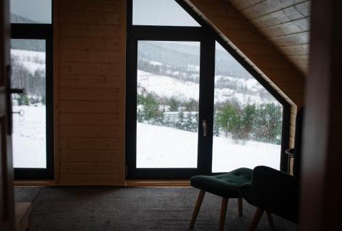 a room with a window looking out at a snow covered yard at Widokowe Stodoły in Chyszówki