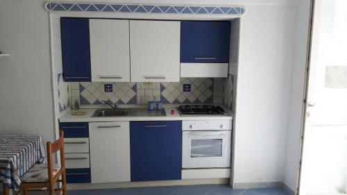 a kitchen with blue and white cabinets and a stove at Casa Acqua Marina Ponza in Ponza