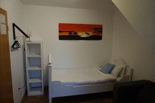 a bedroom with a bed and a painting on the wall at Gästewohnung von J&O am Fluss. in Jork