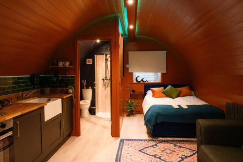 a bedroom with a bed and a bathroom with a sink at Glen Getaway - (Luxury Pod) in Stranraer