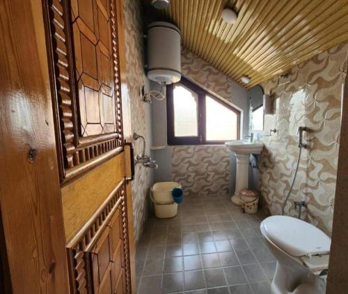 małą łazienkę z toaletą i umywalką w obiekcie Behtereen resort w mieście Śrinagar