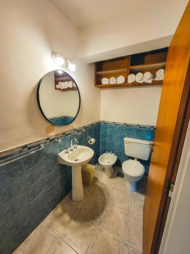 W łazience znajduje się umywalka, toaleta i lustro. w obiekcie Cabaña Oasis w mieście San Martín de los Andes