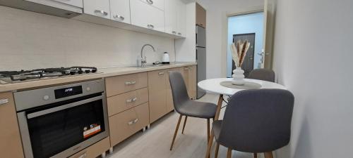 a kitchen with a table and chairs and a stove at Relax Home Apartment Q in Iaşi