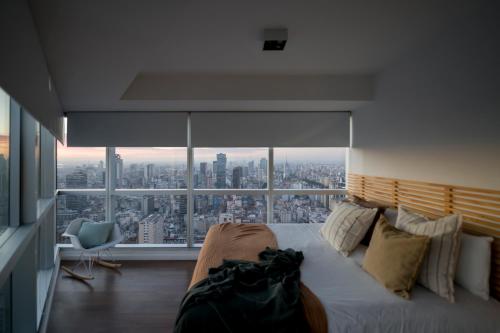 Un dormitorio con una cama con vistas a una ciudad. en Top Rentals Downtown, en Buenos Aires